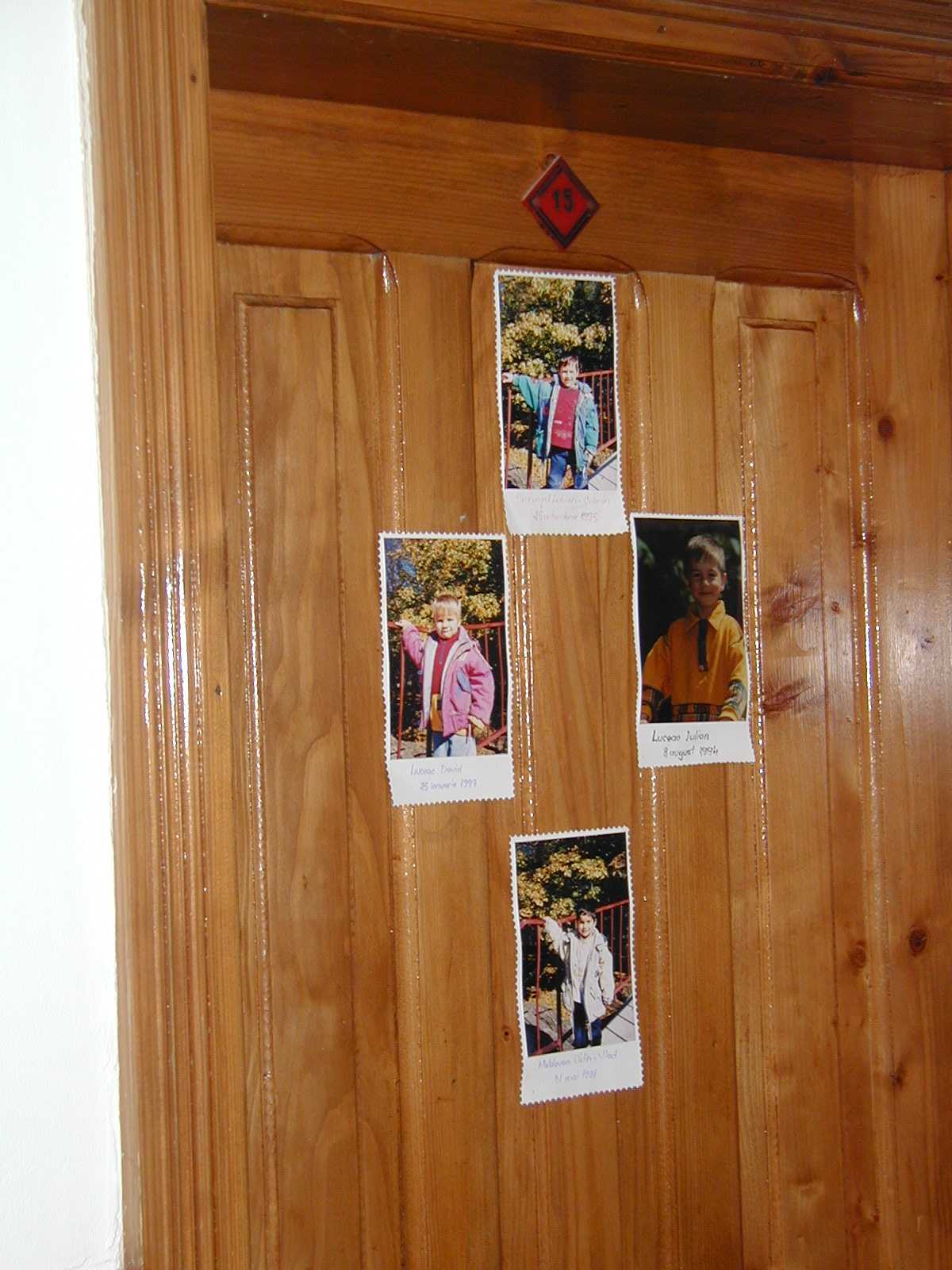The children decorate the door to their room with pictures of themselves.